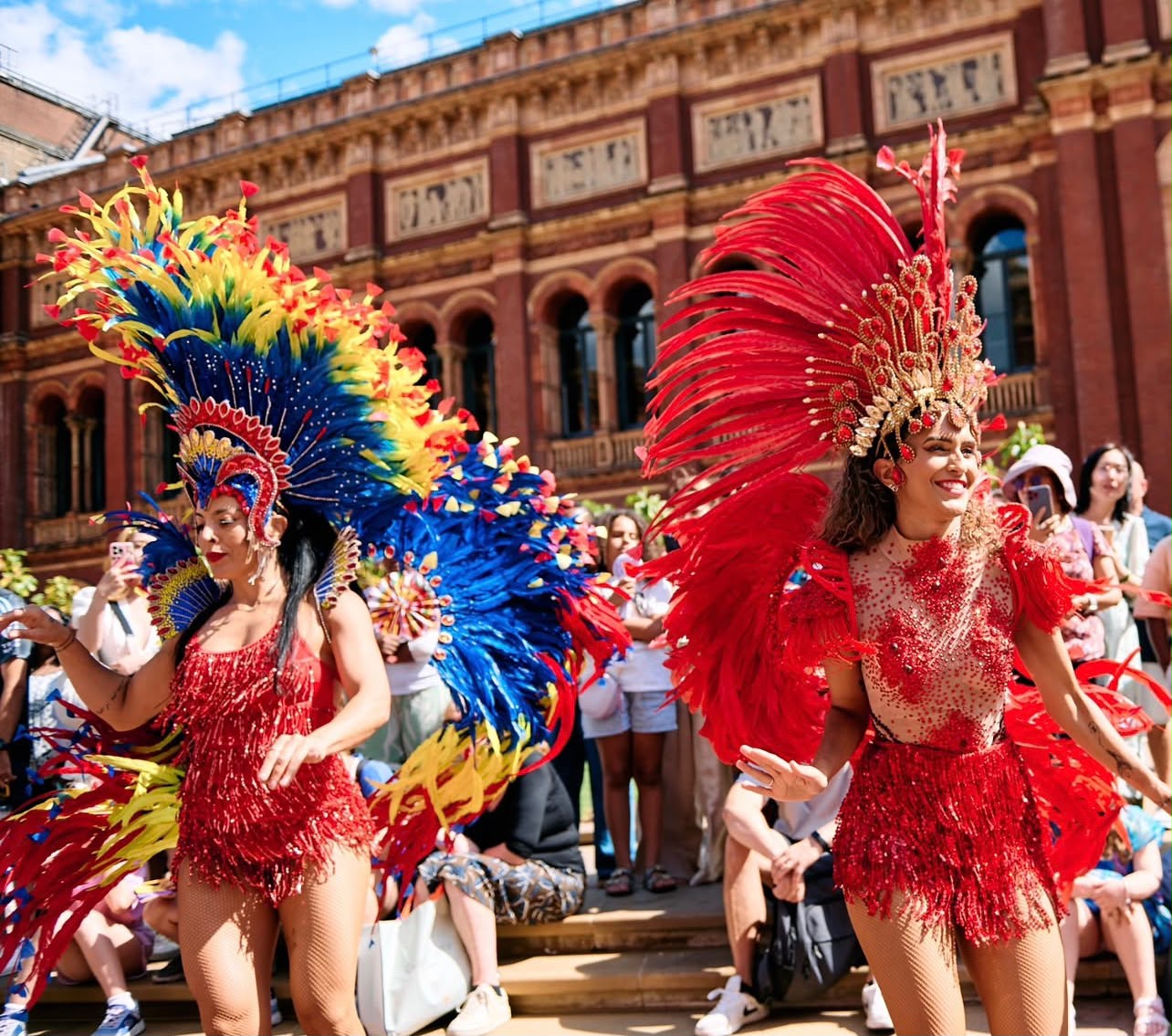 Grazi performing in a red carnival costume alongside another dancer