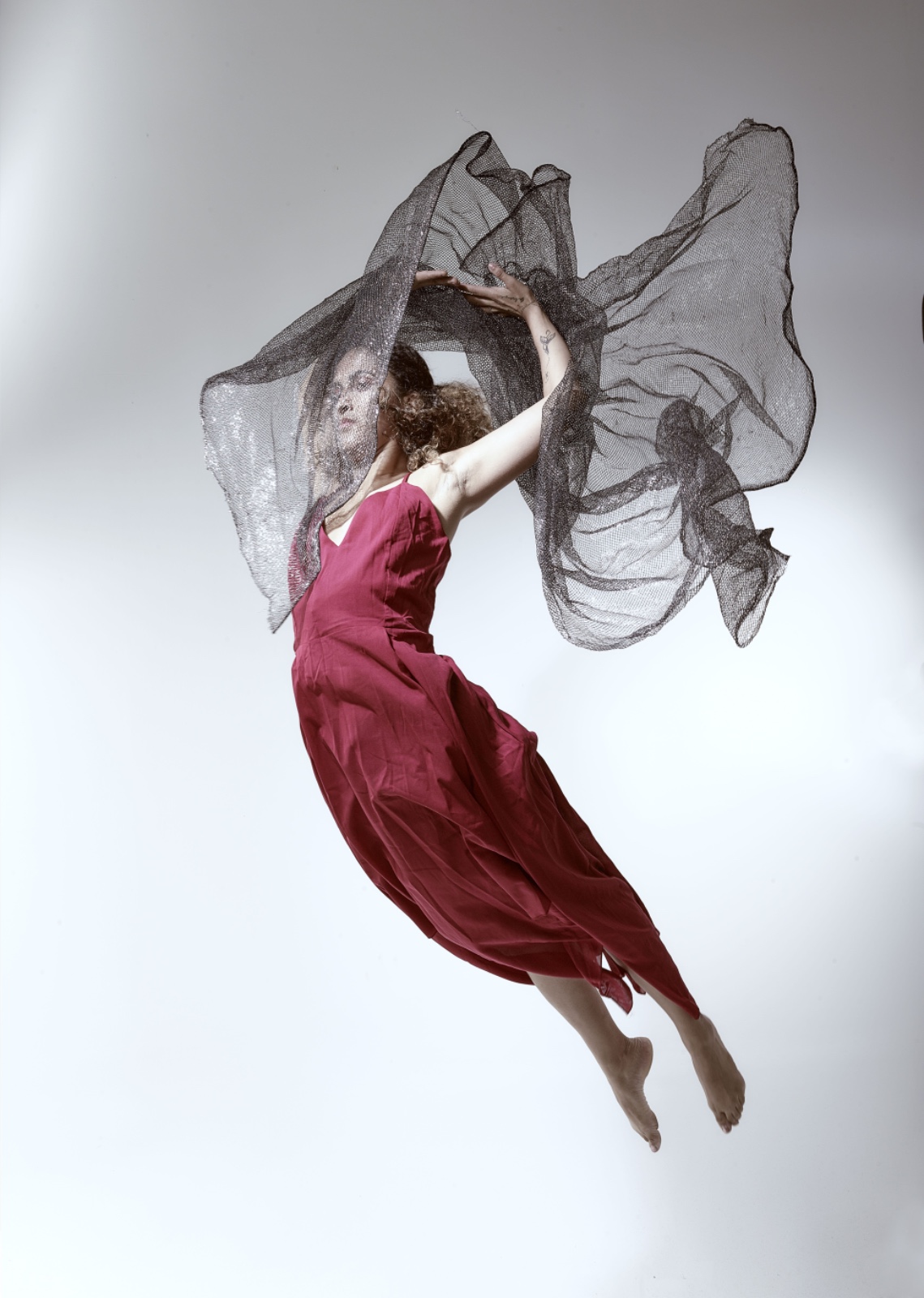 Grazi performing an artistic dance with flowing black fabric