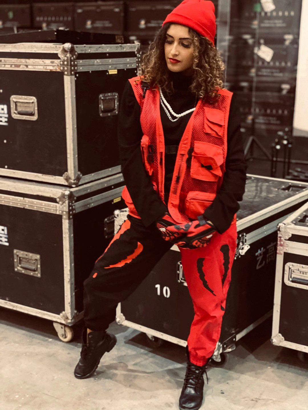 Grazi wearing a red and black dance outfit backstage