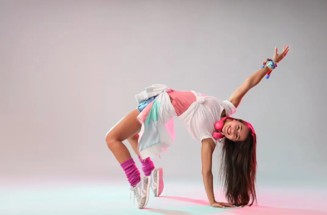 A young dancer in a colourful dance pose
